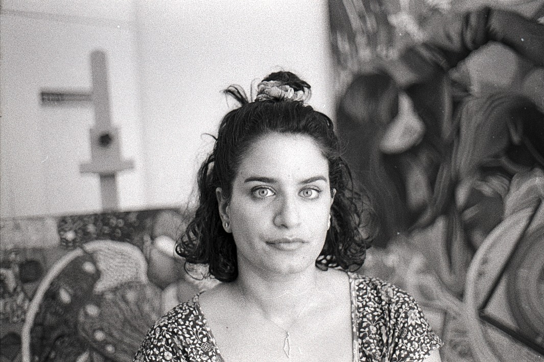 Portrait of artist Lama Almoayyed in her Bahrain studio, surrounded by her contemporary surrealist oil paintings.